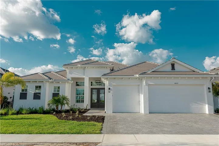 View of front of property with extended driveway for protection against hard water & extra room, stucco siding, a front lawn, a garage, and a tiled roof, upgraded matte black coach lighting