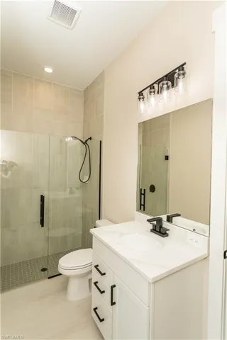 Upgraded pool bathroom with all matte black fixtures, glass shower with floor to ceiling tile upgrade, vanity, and recessed lighting