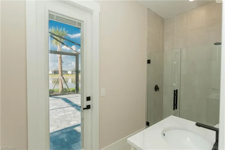 Upgraded pool bathroom with all matte black fixtures, glass shower with floor to ceiling tile upgrade, vanity, and recessed lighting