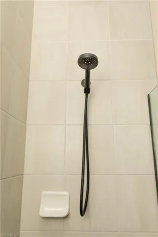 Bathroom view floor to ceiling tile and updated matte black shower fixtures.