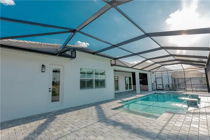 Notice pool bath off lanai, Salt water gas heated concrete pool / spa under screened lanai with sealed pavers and custom outdoor kitchen, views of lake/golf course