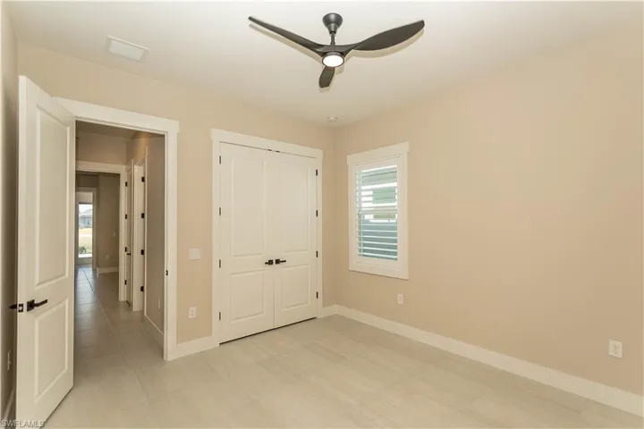 Unfurnished bedroom 1 with custom closet and a ceiling fan