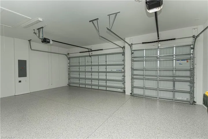 Garage featuring an epoxy finished floor, added attic pull down stairs, attic insulated, added plumbing for sink