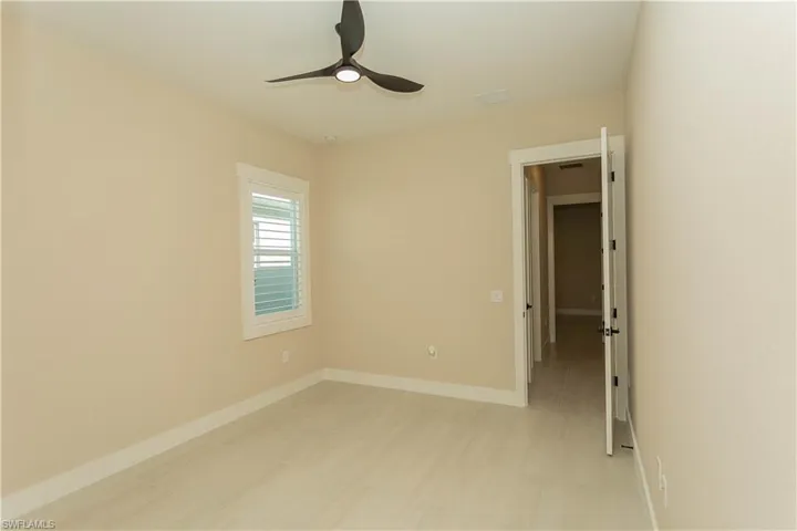 Unfurnished bedroom 1 with custom closet and a ceiling fan