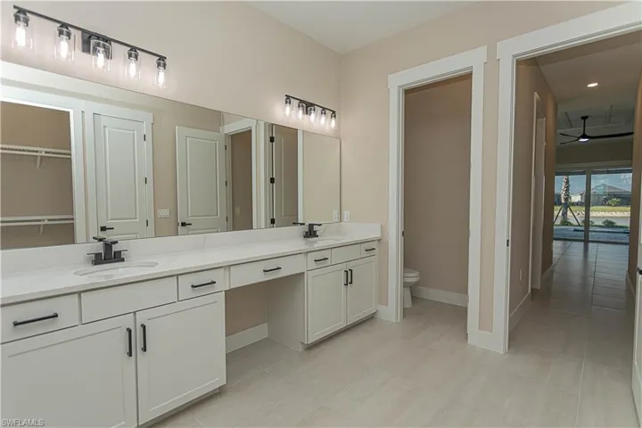 Master bath featuring double vanity, a walk in shower, a spacious custom closet, and recessed lighting, featuring matte black fixtures, floor to ceiling tile in shower