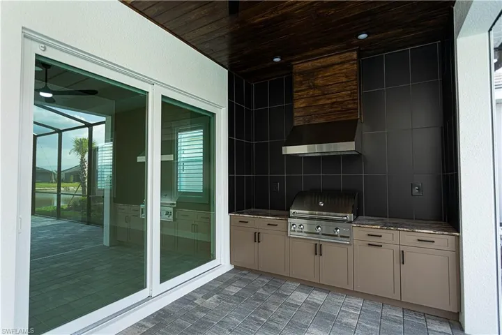 View of lanai with a custom outdoor kitchen featuring tongue and groove ceiling, warranty on grill -no rust, no pitting