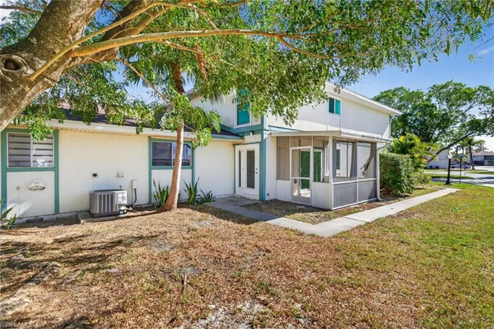 Rear view of property with a sunroom and a yard
