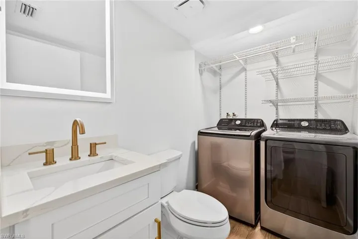 Bathroom with vanity and washer and clothes dryer