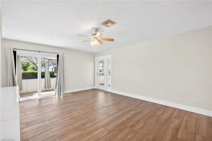 Empty room with wood tiled floors, a textured ceiling, and ceiling fan