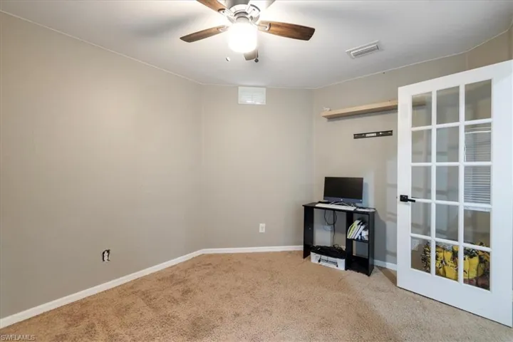 Unfurnished living room featuring ceiling fan and carpet