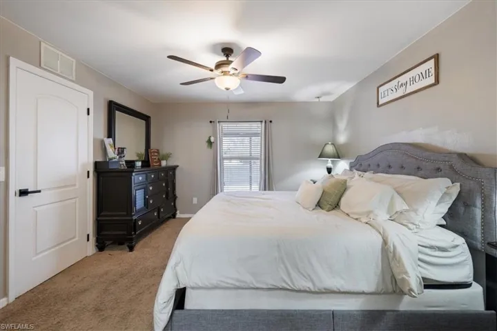 Carpeted bedroom featuring ceiling fan