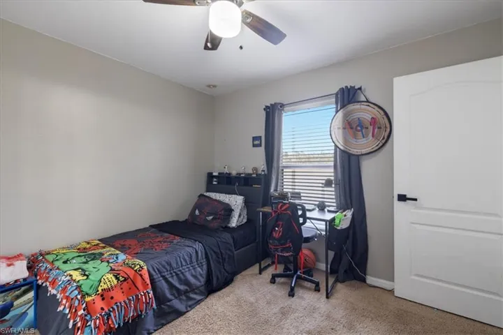 Carpeted bedroom featuring ceiling fan