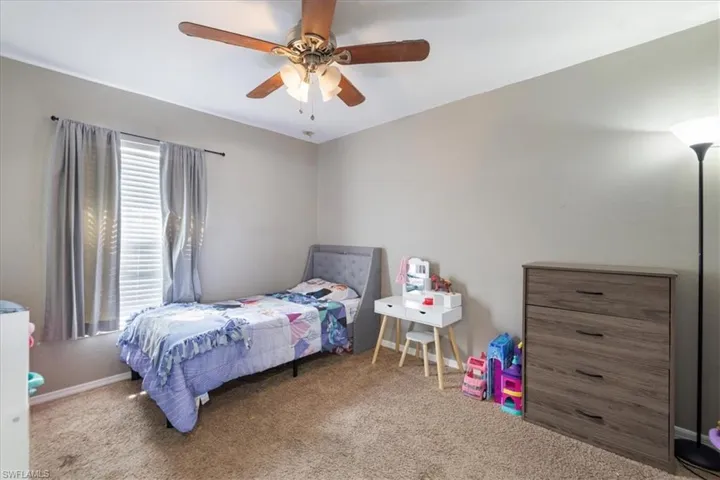 Carpeted bedroom with ceiling fan