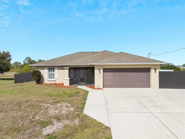 Ranch-style house with a garage and a front lawn