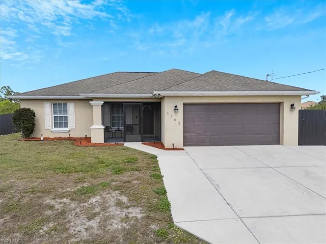 Single story home with a garage and a front yard