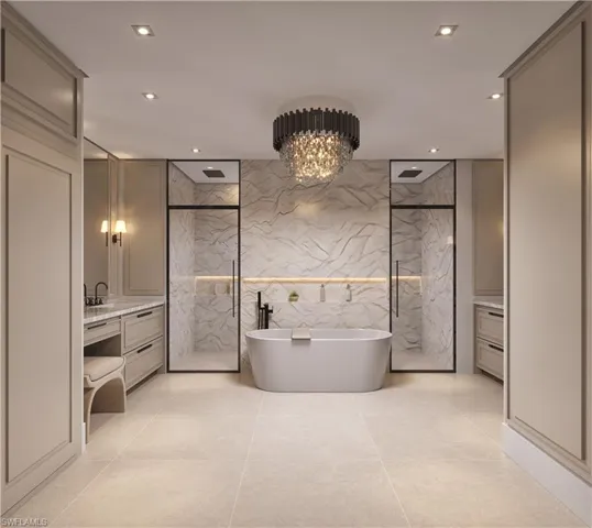 Bathroom with a marble finish shower, tile walls, a freestanding bath, a chandelier, and vanity