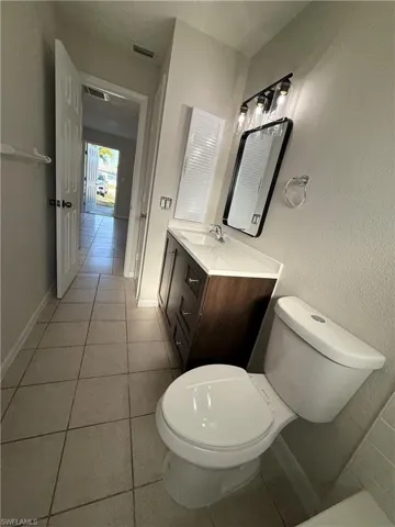 Half bathroom featuring light tile patterned floors and vanity