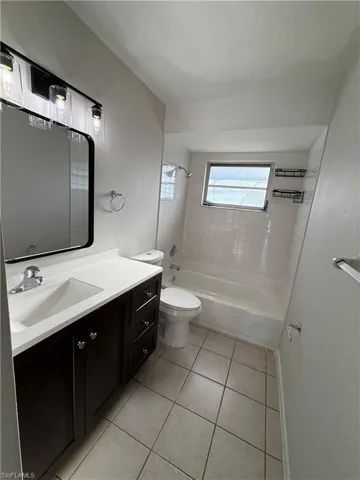 Bathroom with shower / washtub combination, vanity, and light tile patterned floors
