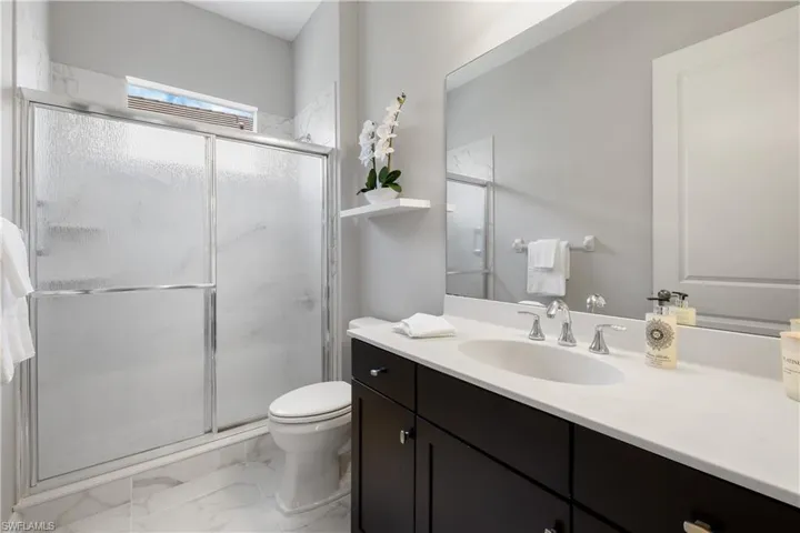 Spare Bathroom featuring tile patterned flooring, toilet, vanity, and an enclosed shower