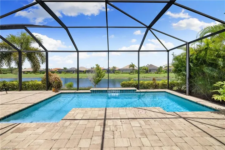 View of swimming pool with a patio, a water view, and a lanai