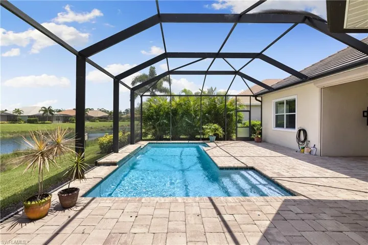 View of swimming pool with a patio and glass enclosure