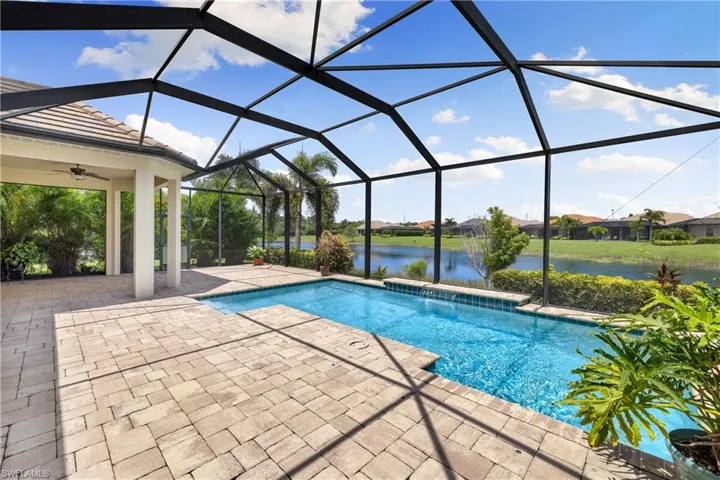 View of swimming pool featuring a lanai, a water view, a patio, and ceiling fan