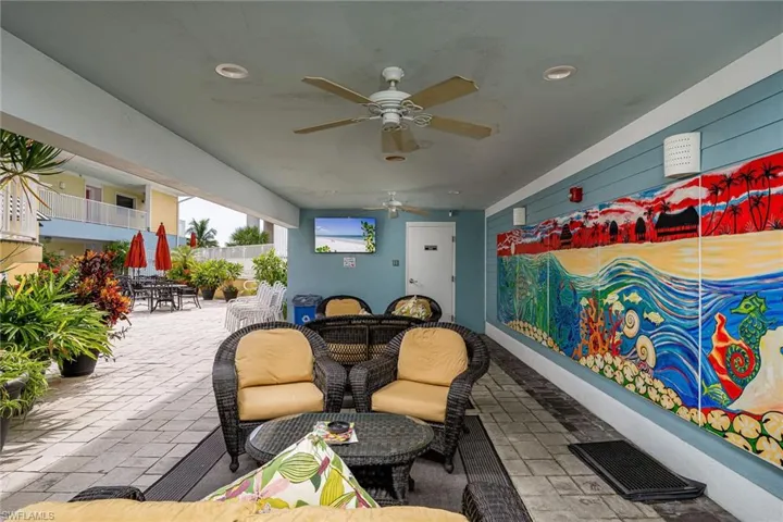 Covered outdoor patio featuring extensive hardscaping, ceiling fans, and recessed lighting