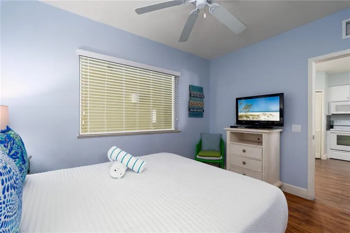 Interior room featuring a ceiling fan, window with horizontal blinds, and a built-in dresser