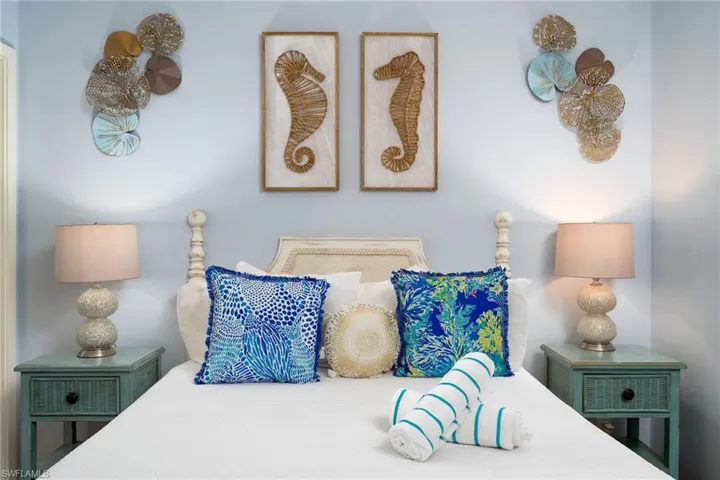 Bedroom featuring a light blue wall color, a decorative headboard, and two nightstands with built-in drawers