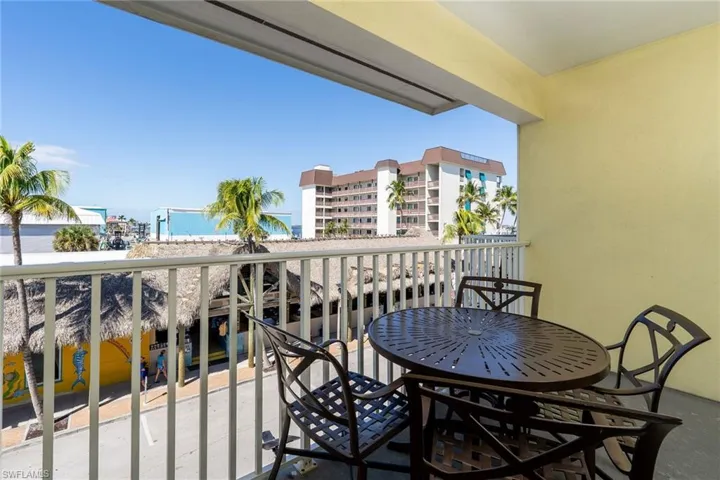 Outdoor balcony featuring a painted concrete floor, textured yellow wall, and white railing