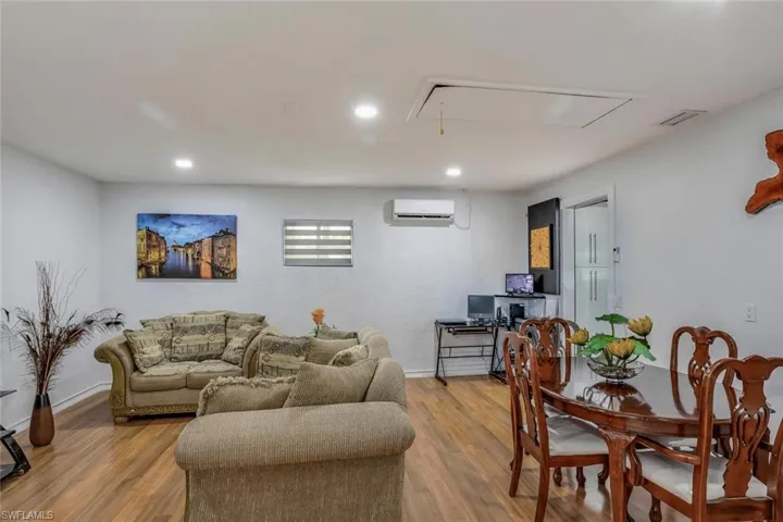 Living room featuring a wall mounted AC and light wood-type flooring