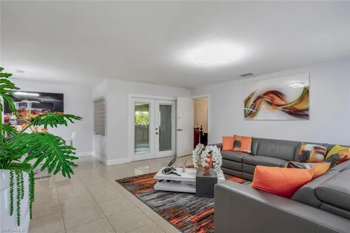 Living room featuring french doors and light tile floors
