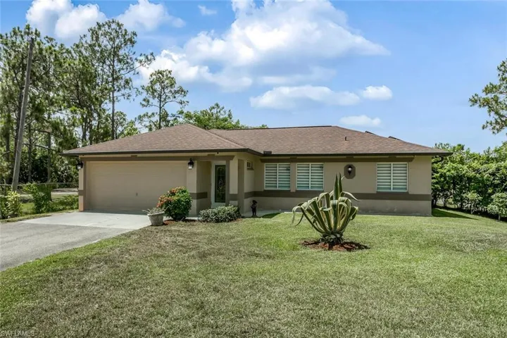 Single story home featuring a garage and a front lawn
