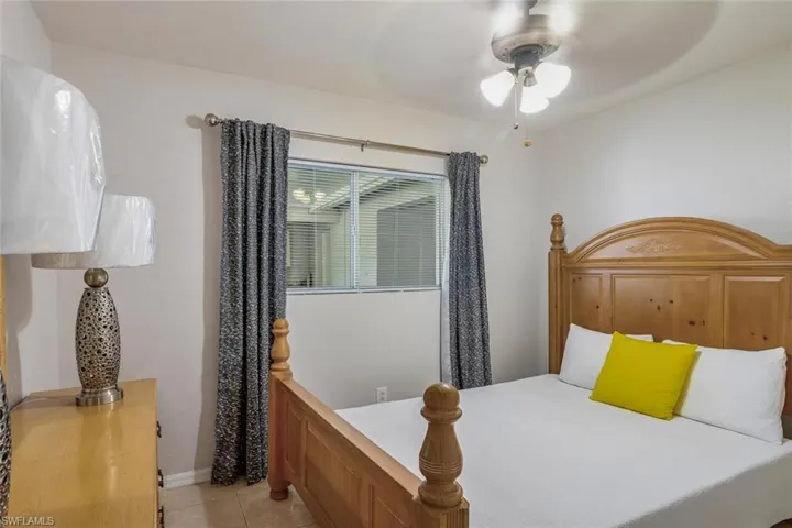 Bedroom with ceiling fan and light tile floors