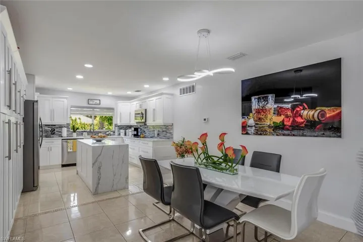 Dining space with sink and light tile floors