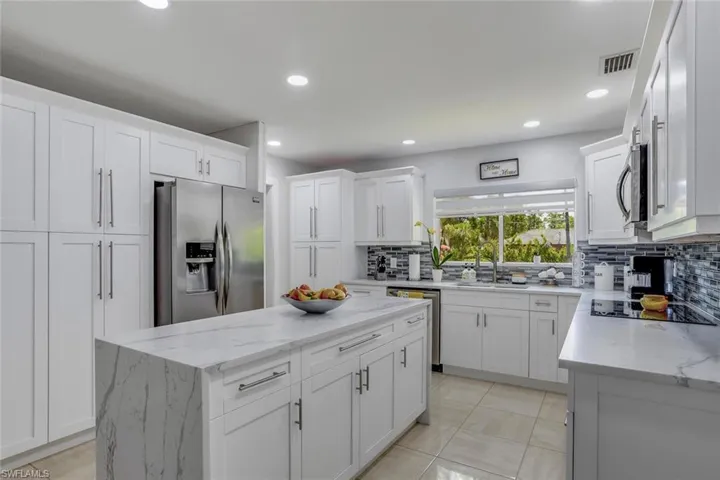 Modern Updated Kitchen with appliances with stainless steel finishes, white cabinets, and tasteful backsplash