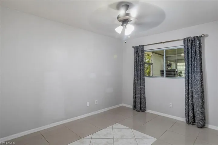 Tiled spare room with ceiling fan