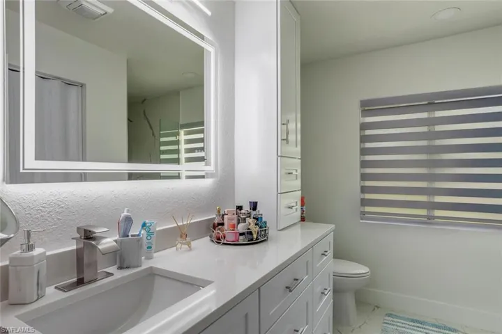 Owners Bathroom featuring brand new vanity with extensive cabinet space, tile flooring, and toilet