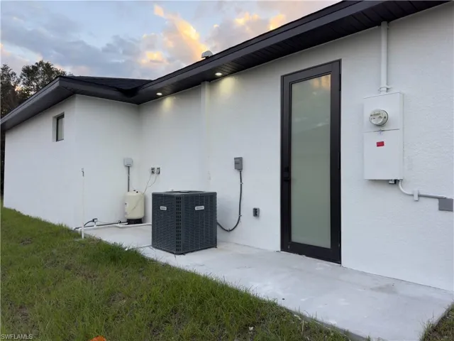 Property exterior at dusk with a patio area and stucco siding