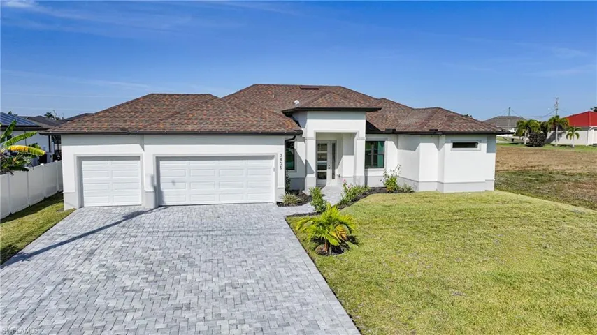 Prairie-style house featuring stucco siding, decorative driveway, an attached garage, and a shingled roof