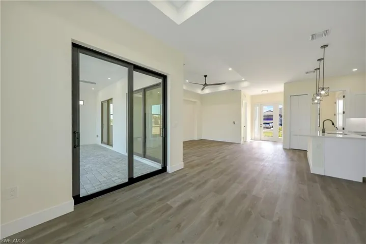Unfurnished living room featuring light wood-style floors, a ceiling fan, and recessed lighting