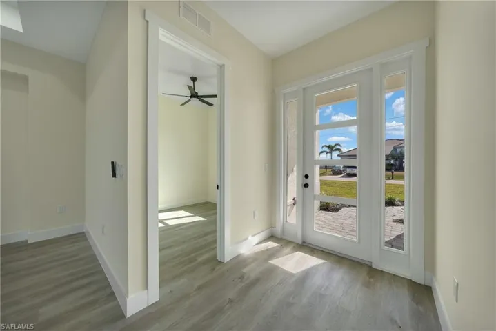 Doorway to outside with wood finished floors and a ceiling fan
