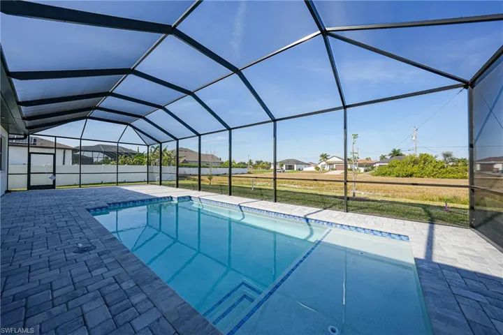 View of pool with a sunroom, a lanai, a lawn, a patio area, and a residential view