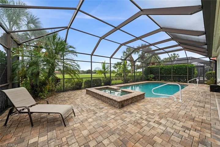 Screened enclosure with a swimming pool, integrated spa, paver patio overlooking the golf course at Twin Eagles County Club