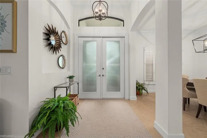 Double entry doors with textured glass panels, and a decorative overhead light fixture