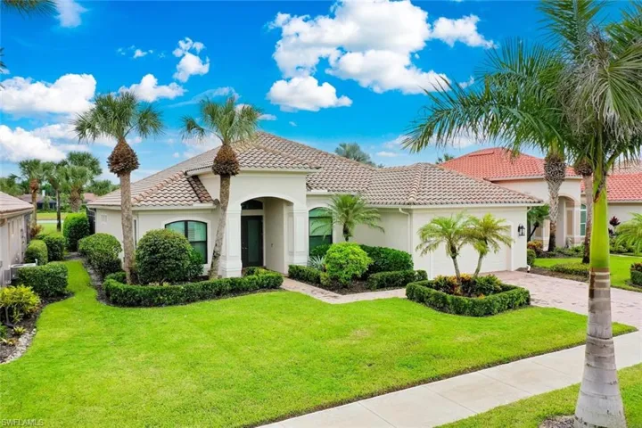 TwinEagles single-story residence featuring a tile roof, stucco exterior, brick paver driveway and two-car garage