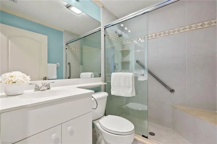 Bathroom featuring vanity, toilet, and walk in shower