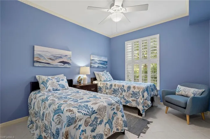 Tiled bedroom with ceiling fan and ornamental molding