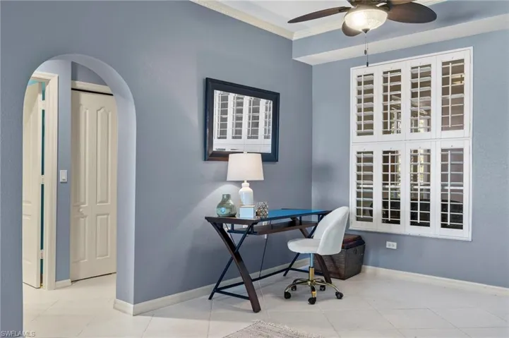 Tiled home office with ceiling fan and crown molding