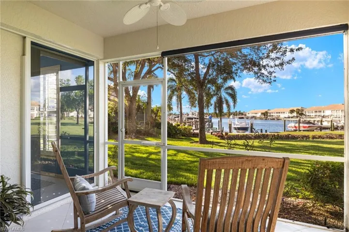Sunroom featuring ceiling fan and a water view